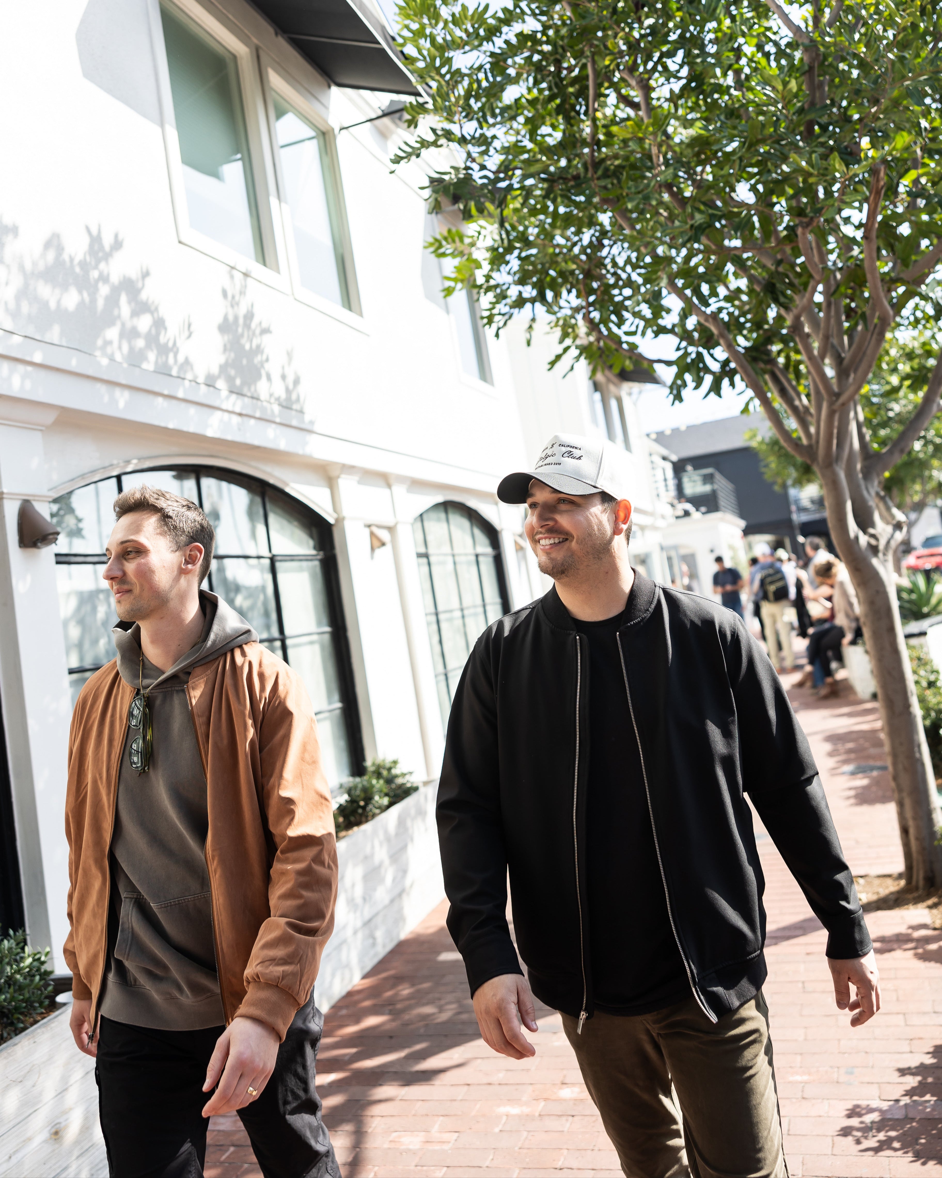 Men’s elevated basic look with brown corduroy jacket and hoodie layered outfit, and black bomber jacket paired with Nostalgic Collective embroidered trucker hat – everyday fashion by Stitched Apparel branded as STCHD