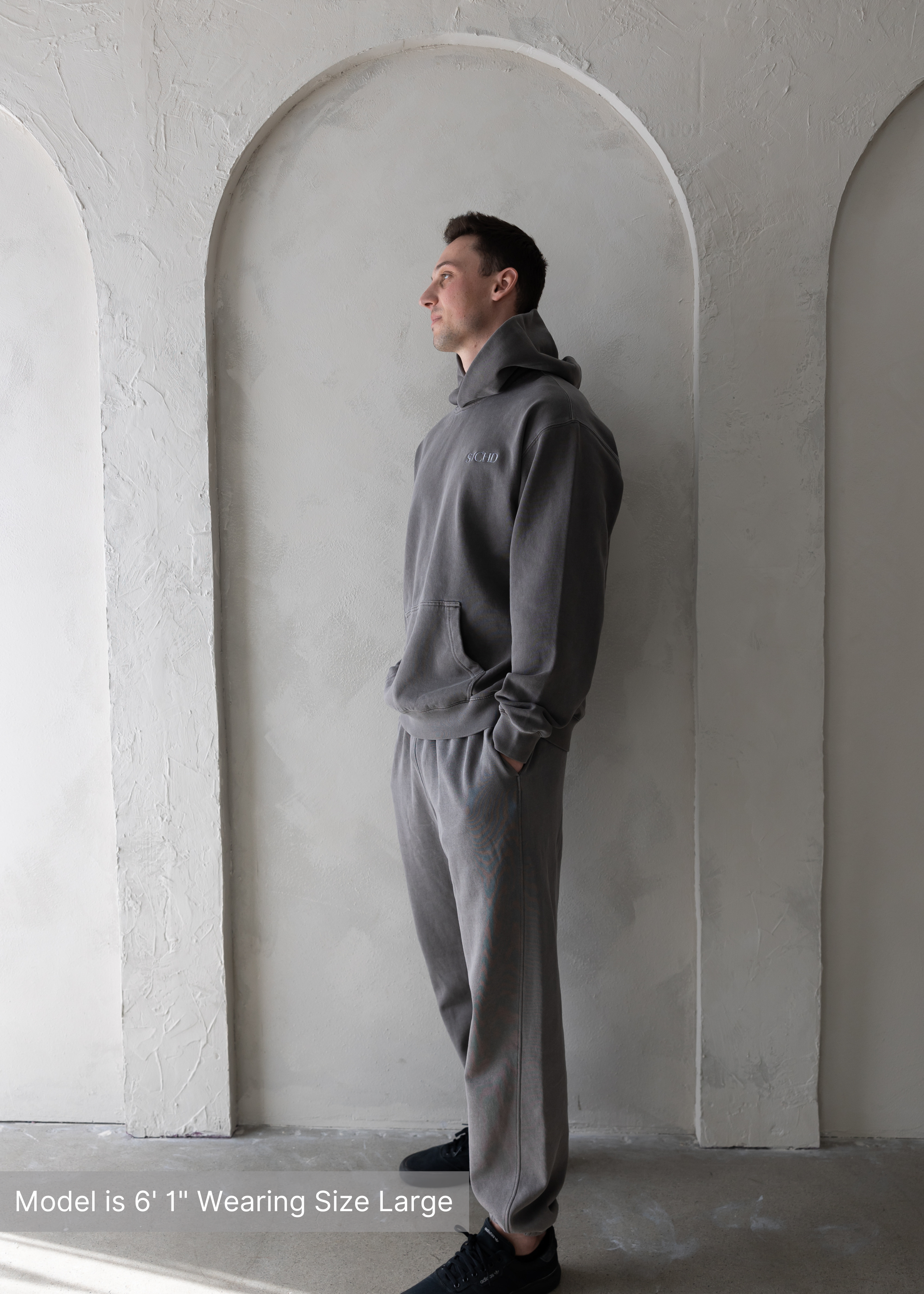 Side profile of man wearing washed grey hoodie and joggers by stitched apparel branded as stchd, cozy modern loungewear for men.